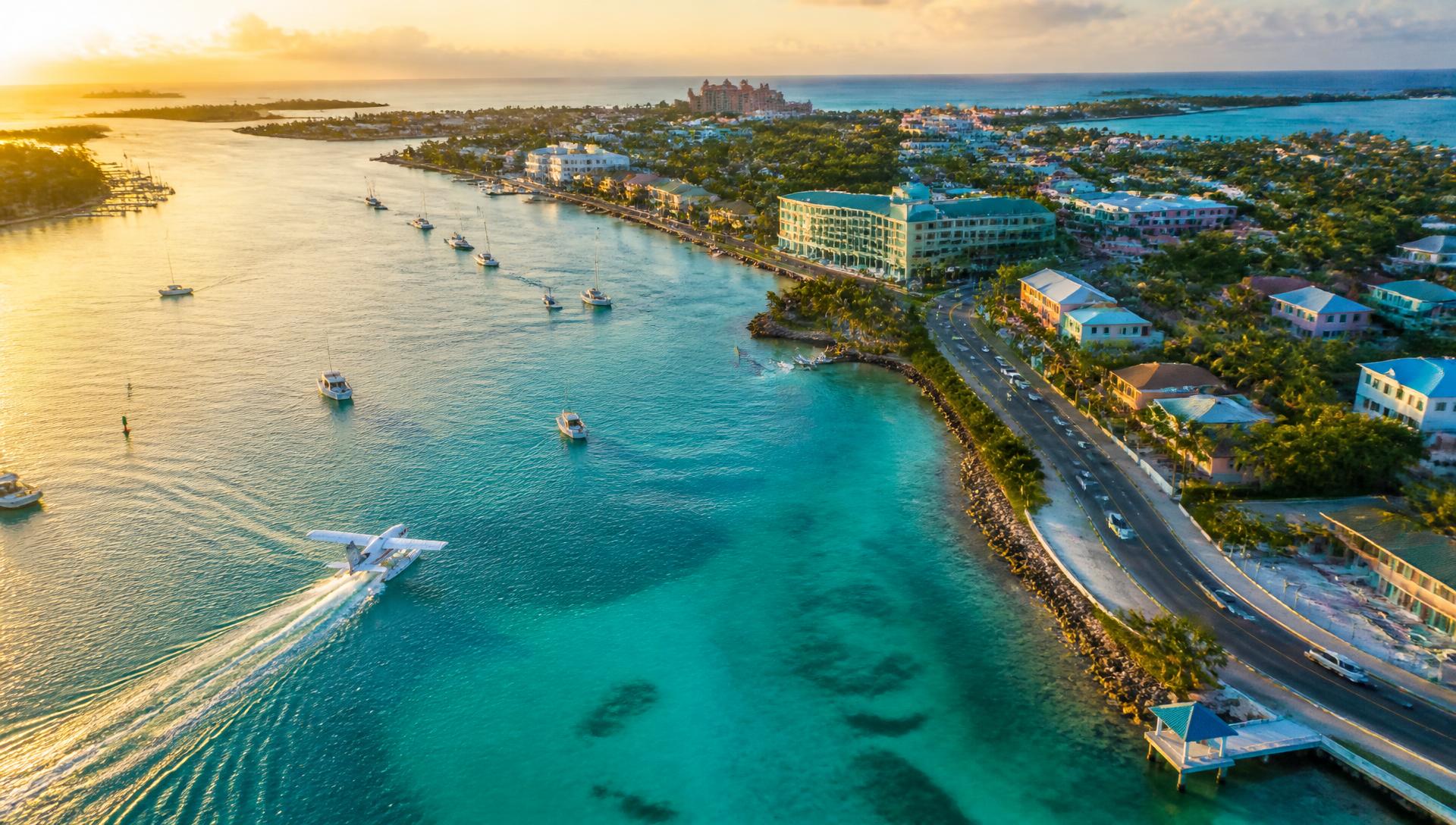 Aerial view of Nassau, The Bahamas, with turquoise water, boats, a seaplane and a coastal road